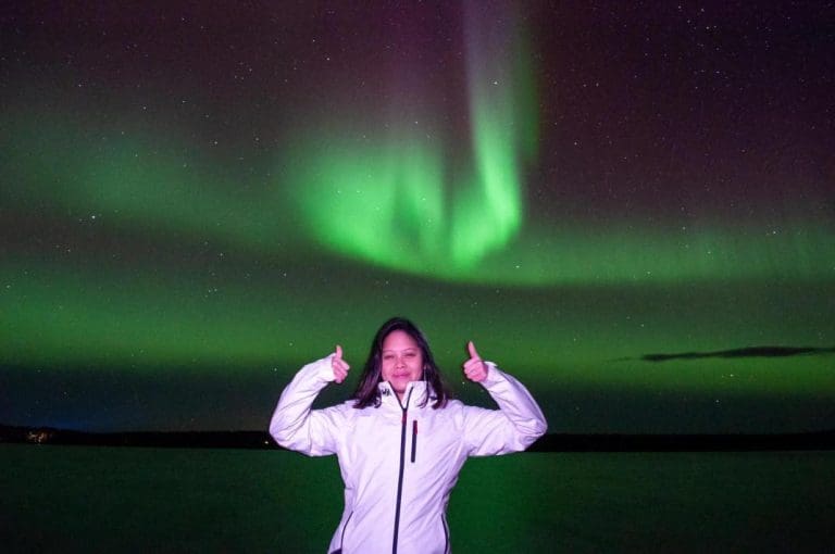 Purple and green aurora lights over lake