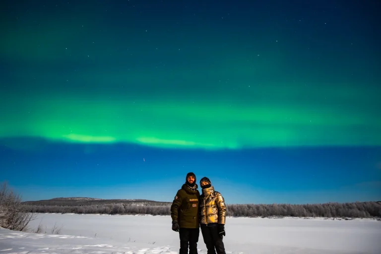 Couple experiencing a Northern Lights tour in Rovaniemi